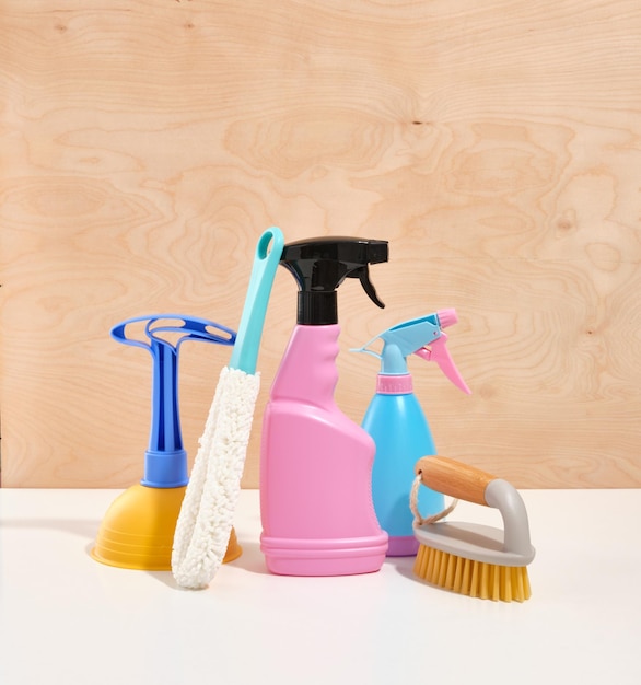 Een samenstelling van huishoudelijke of kantoorreinigingsmiddelen op een houten achtergrond een zuiger voor het verwijderen van verstoppingen