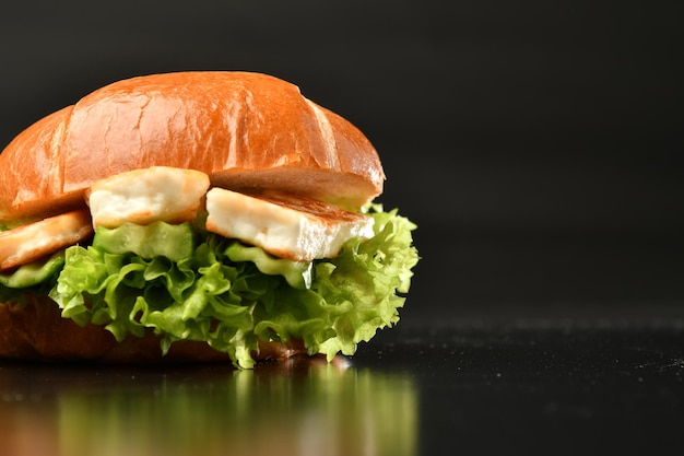 Een sandwich met een kant van sla en kaas op een zwarte achtergrond