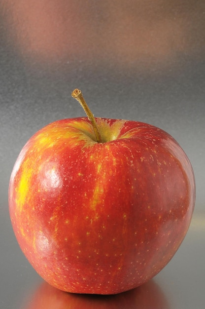 Een sappige hete rode appel op een gekleurde achtergrond