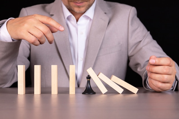 Een schaakpion zorgt ervoor dat een houten domino niet valt