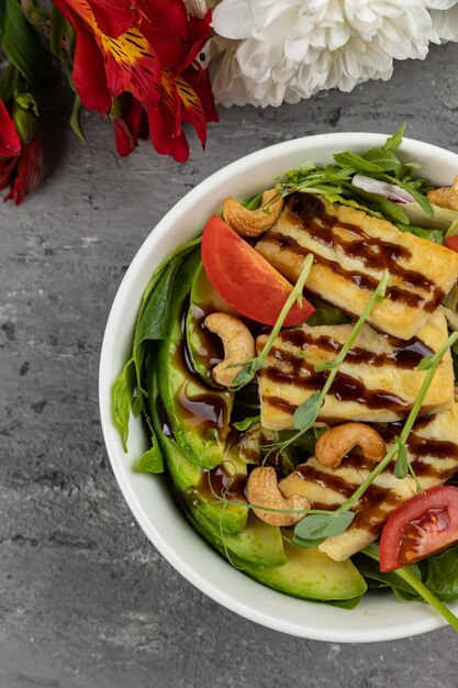 Een schaal met eten met een rode bloem aan de zijkant