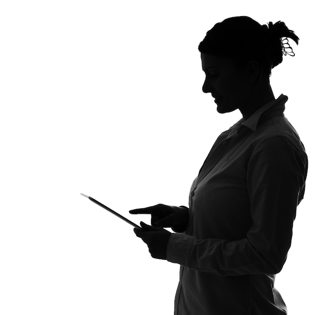 een schaduw van een vrouw die op een tablet werkt over wit