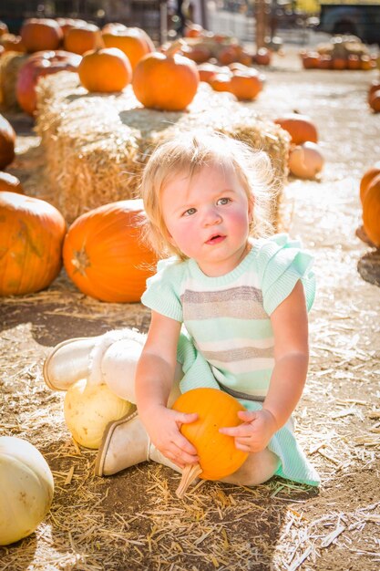 Een schattig baby meisje die plezier heeft op een rustieke ranch in de Pumpkin Patch.