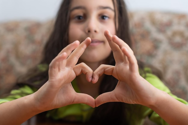 Een schattig blank kind houdt een handpalm vast in de vorm van een hart.