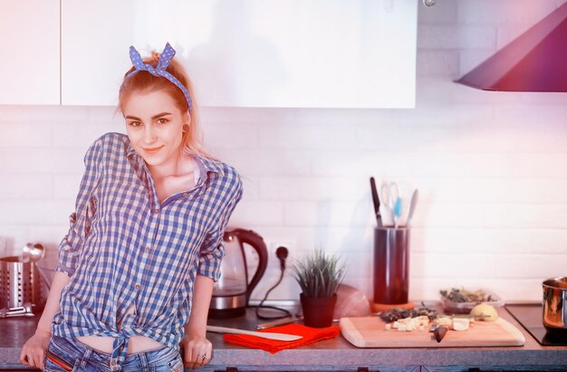 Foto een schattig jong meisje in de keuken bereidt het diner voor