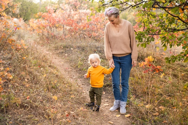 Een schattig jongetje met zijn moeder in het herfstbos