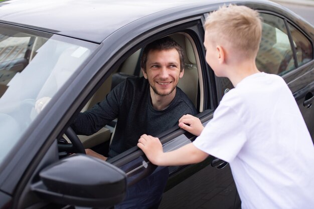 Een schattig kind gaat met een gelukkige vader naar het werk Papa zit in de auto