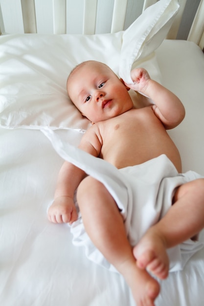 Een schattig kind ligt in een babybed