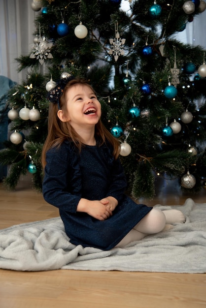 Een schattig klein meisje in de buurt van de kerstboom Kerstmis Nieuwjaar