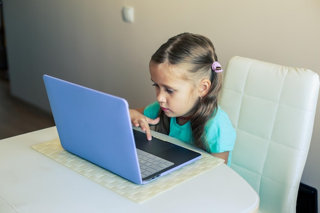 Foto een schattig meisje gebruikt een laptop om videogesprekken te maken.