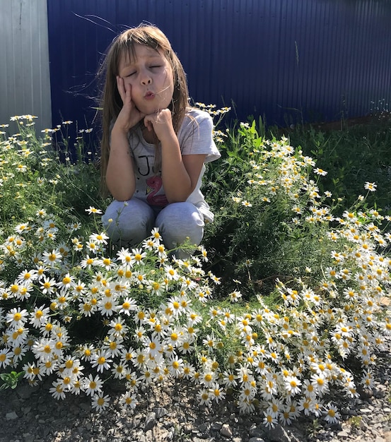 Foto een schattig meisje kruipt tussen bloeiende planten.