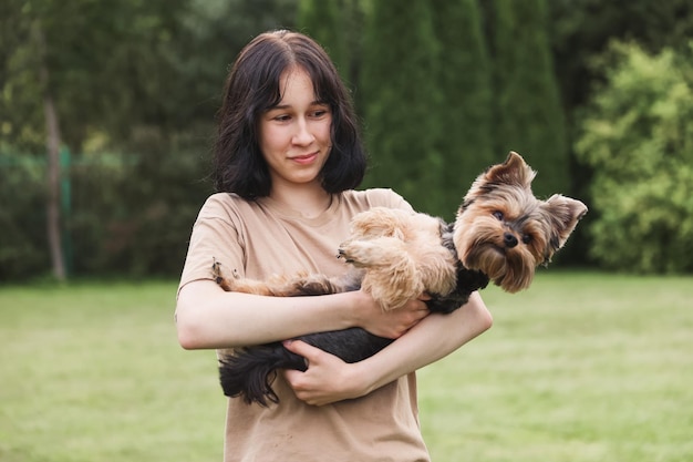 Een schattig meisje met een Yorkshire terrier op straat Knuffels met je kleine hond in het park