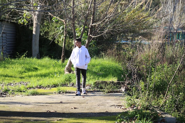 Foto een schattige kleine jongen die in het buitenbospark loopt.