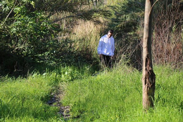 Foto een schattige kleine jongen die in het buitenbospark loopt.