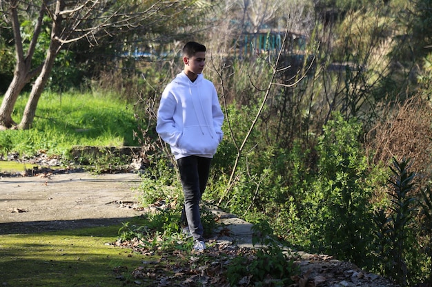 Foto een schattige kleine jongen die in het buitenbospark loopt.