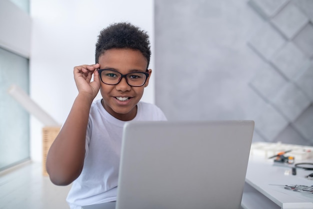 Een schattige tiener die achter de laptop zit en er betrokken uitziet