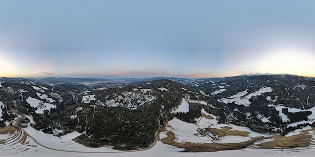 Een schilderachtig uitzicht op besneeuwde bergen tegen de hemel bij zonsondergang