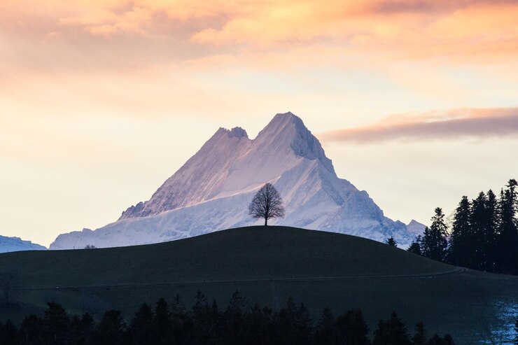 Foto een schilderachtig uitzicht op besneeuwde bergen tegen de hemel bij zonsondergang