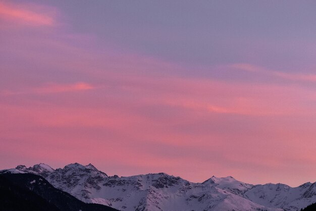 Foto een schilderachtig uitzicht op besneeuwde bergen tegen de hemel bij zonsondergang