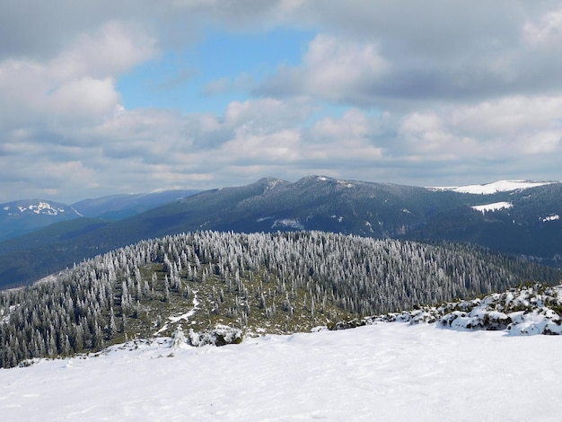 Een schilderachtig uitzicht op besneeuwde bergen tegen een bewolkte lucht