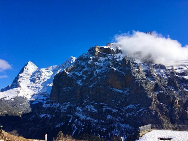 Foto een schilderachtig uitzicht op besneeuwde bergen tegen een blauwe hemel