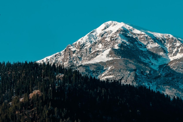 Een schilderachtig uitzicht op besneeuwde bergen tegen een heldere blauwe lucht