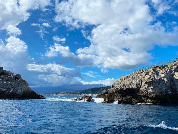 een schilderachtig uitzicht op de rotsen in de zee tegen de achtergrond van de kust van Sicilië