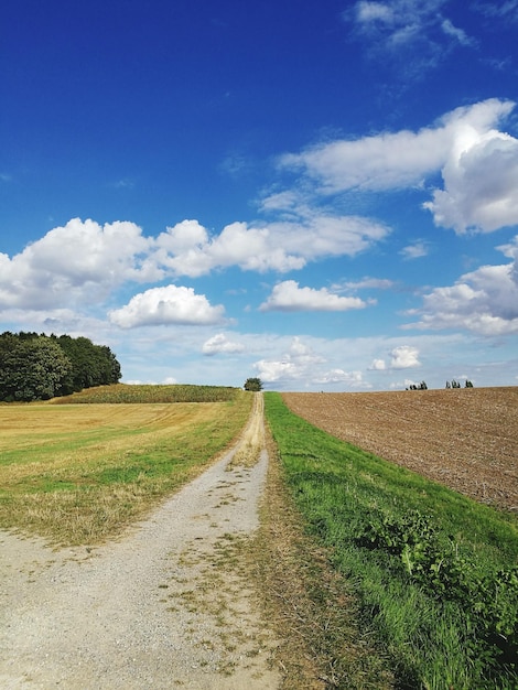 Een schilderachtig uitzicht op een landelijke weg tegen een bewolkte lucht