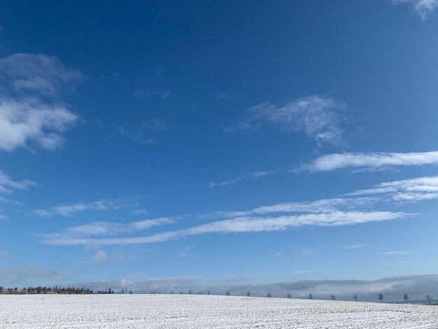 Een schilderachtig uitzicht op een met sneeuw bedekt veld tegen een blauwe hemel