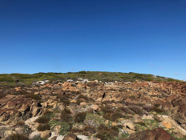 Een schilderachtig uitzicht op een rotsachtig landschap tegen een heldere blauwe hemel