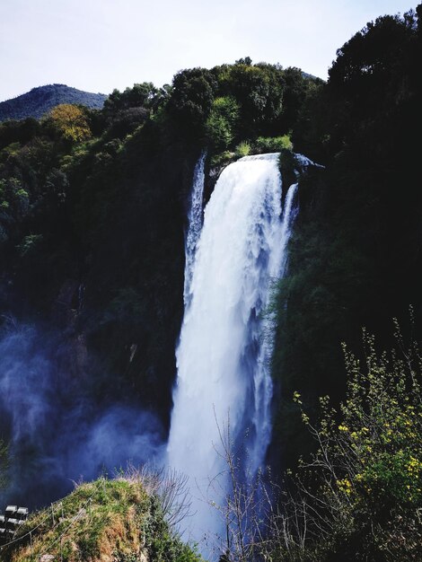 Foto een schilderachtig uitzicht op een waterval in het bos tegen de lucht