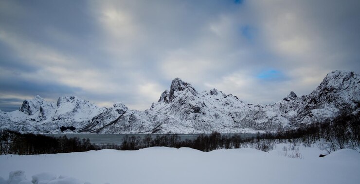 Foto een schilderachtig uitzicht op het meer door besneeuwde bergen tegen de lucht
