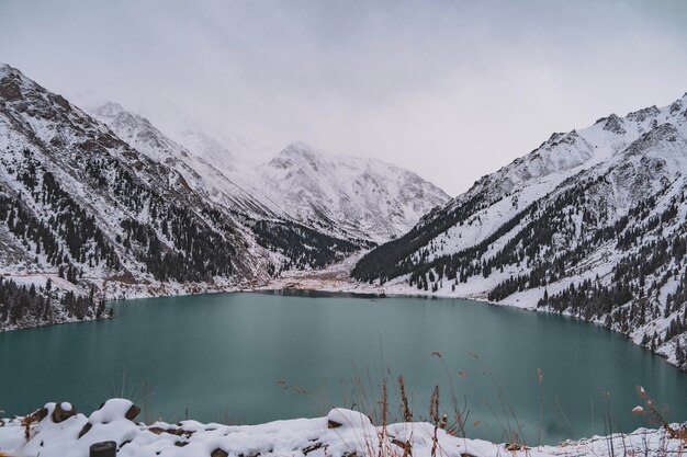 Foto een schilderachtig uitzicht op het meer en de met sneeuw bedekte bergen tegen de lucht