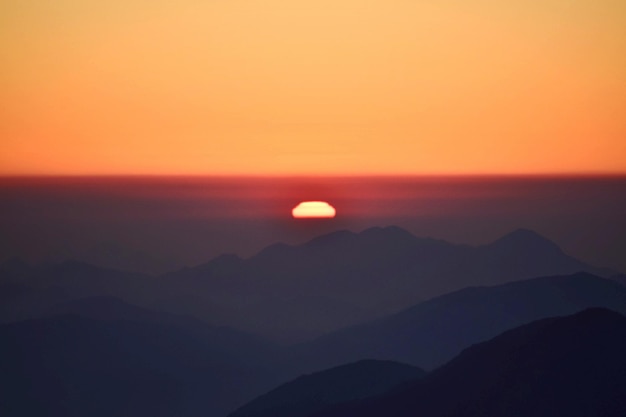 Foto een schilderachtig uitzicht op silhouette bergen tegen een romantische hemel bij zonsondergang