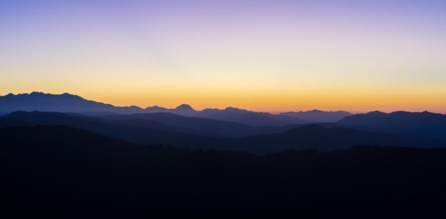 Foto een schilderachtig uitzicht op silhouetten van bergen tegen de hemel bij zonsondergang