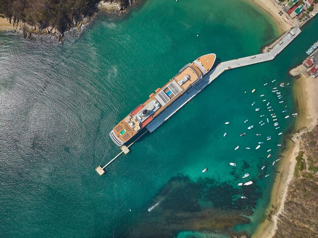 Foto een schip in een watermassa met een dok op de voorgrond en het woord royal caribbean op de bodem.