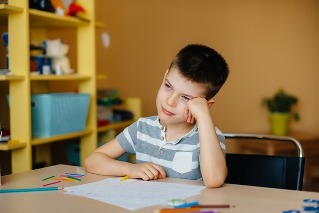 Een schoolgaande jongen maakt thuis huiswerk. opleiding op school