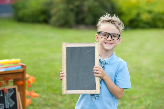 Een schooljongen die een schoolbord houdt