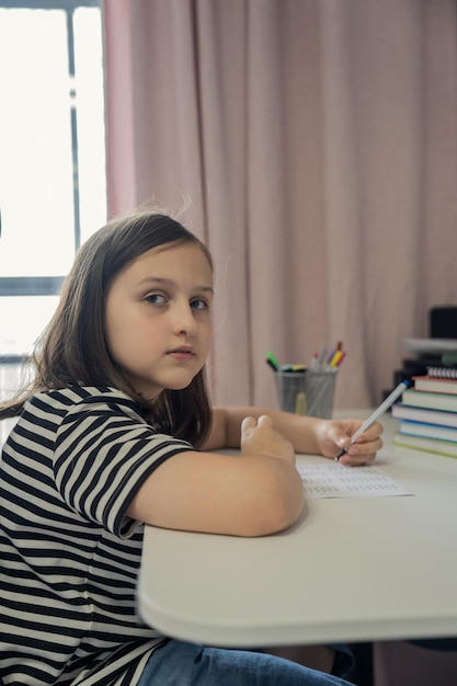 Een schoolmeisje doet thuis haar huiswerk. Het concept van terug naar school.