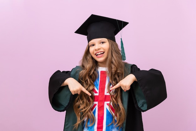 Een schoolmeisje in afstudeeruniform wijst met haar vingers naar de vlag van Groot-Brittannië.