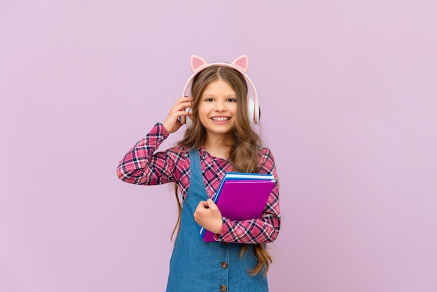 Een schoolmeisje leert een vreemde taal in de audioversie Een meisje luistert naar een audioboek