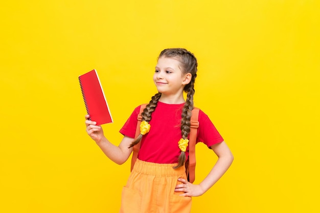 Een schoolmeisje met een schooltas maakt zich klaar om naar school te gaan kinderonderwijs voorbereidende cursussen voor schoolkinderen aanvullende lessen voor succesvolle examens gele geïsoleerde achtergrond