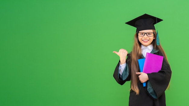 Een schoolmeisje met schoolboeken op een groene geïsoleerde achtergrond. ruimte kopiëren.