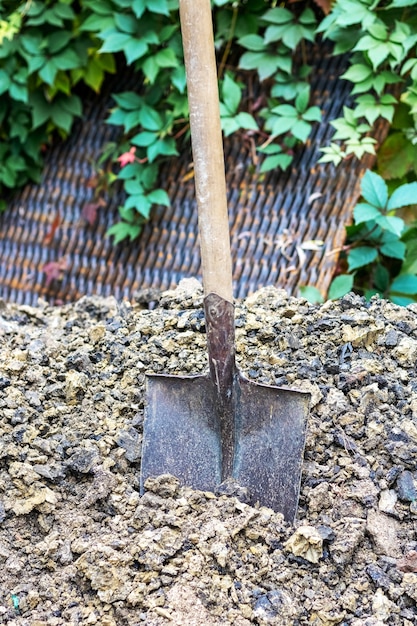 Een schop voor het graven van sleuven zit vast in de grond