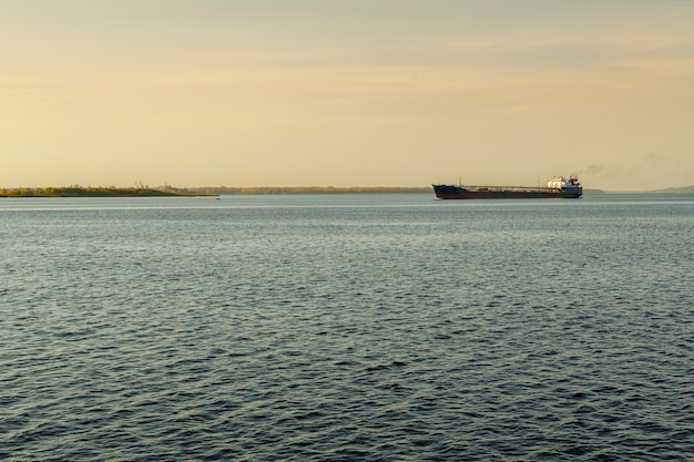 Een schuit in de verte op het water van een grote bevaarbare rivier. Horizontale foto