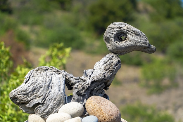 Een sculptuur van steen en hout in de vorm van een vogel in een nest.