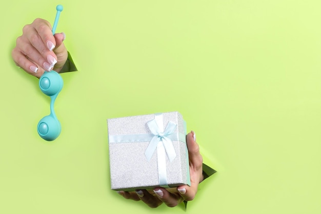 Een seksspeeltje en een geschenkdoos op een groene achtergrond Vrije tijd voor volwassenen Cadeau