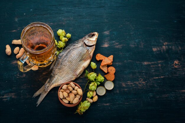 Een selectie van bier en snacks Licht bier donker bier live bier Op een zwarte houten achtergrond Vrije ruimte voor tekst Bovenaanzicht