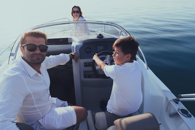 Foto een senior koppel in casual outfits met hun zoon geniet tijdens het varen op een boot op zee bij zonsondergang van de conc