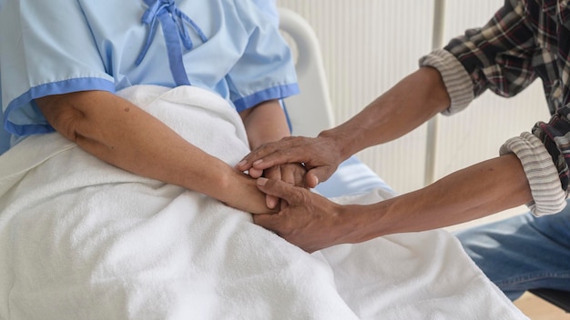 Een Senior man die een senior patiënt vrouw bezoekt in de ziekenhuisgezondheidszorg en medisch concept